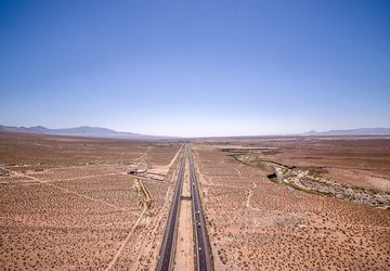 Dry Arizona desert terrain under a bright blue sky