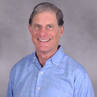 Headshot of Doug Lober smiling at the camera in a blue button-down shirt