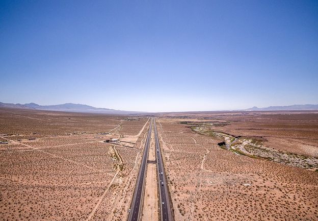 Dry Arizona desert terrain under a bright blue sky